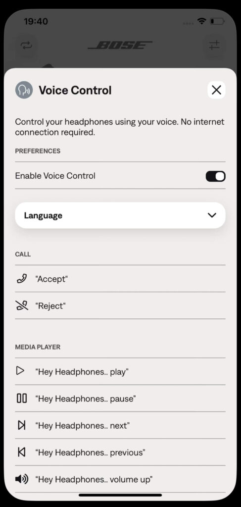 Voice Control settings screen in the Bose QuietComfort Earbuds app. The screen displays options to enable voice control, set the language, and examples of voice commands like ‘Hey Headphones, play,’ ‘pause,’ ‘next,’ and ‘volume up.’ A toggle switch for enabling voice control is visible, set to ‘on’.