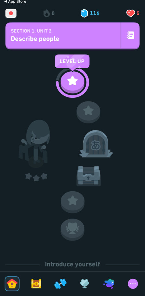 The Duolingo app interface showing a purple banner labeled “SECTION 1, UNIT 2 - Describe people” with a glowing purple “LEVEL UP” button below. Icons at the top display 0 flame points, 116 gems, and 5 hearts remaining. A partially visible gray illustration of a character holding shopping bags is shown below, along with faintly illuminated lesson progress icons leading toward an animated treasure chest.