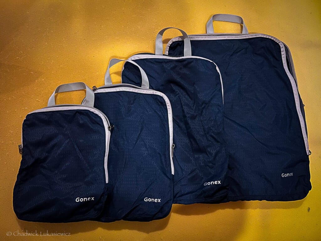 Four Gonex compression packing cubes in navy blue, organized by size, for efficient ADHD-friendly travel packing.