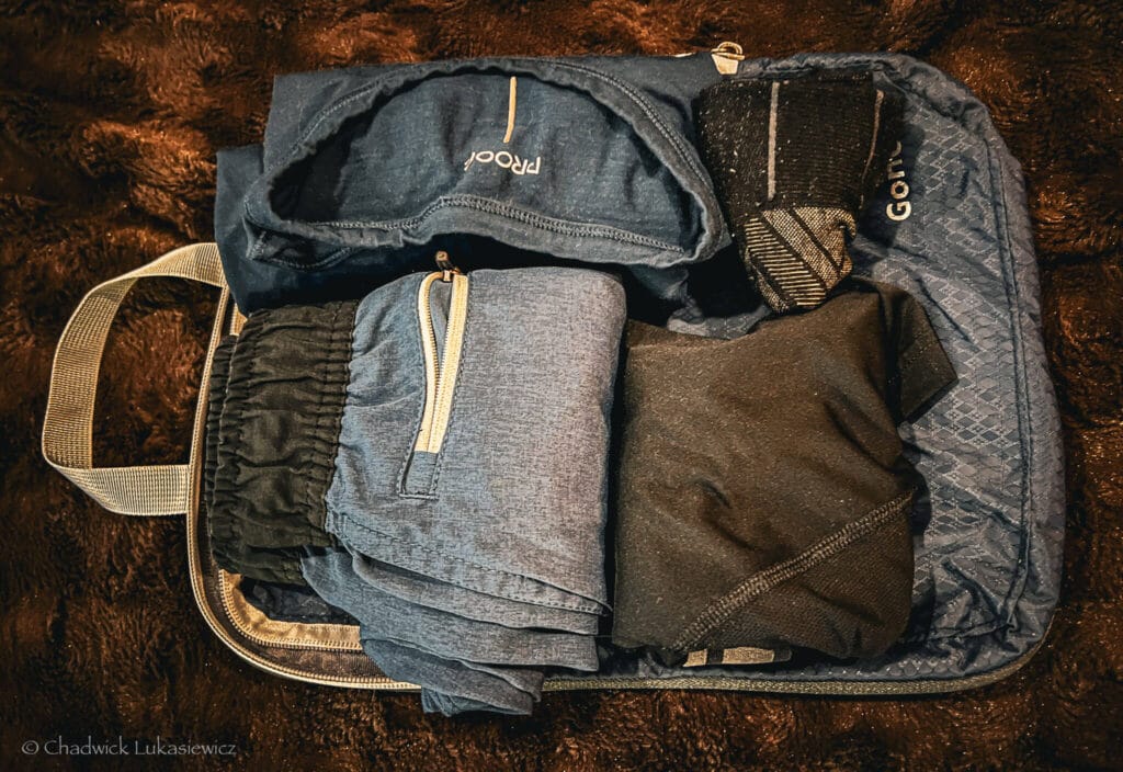 A navy Gonex compression cube packed with rolled clothing, illustrating minimalist outfit packing for ADHD travelers.