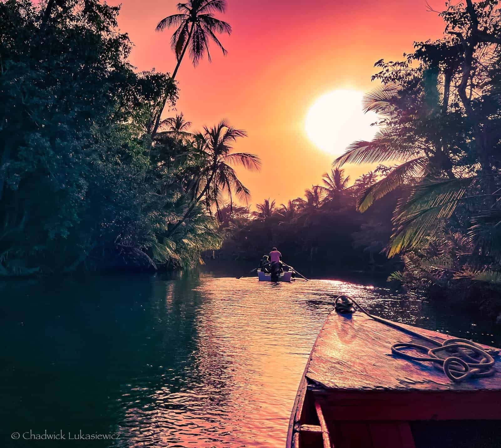 A wooden boat navigating the Indian River in Dominica at sunset, showcasing ADHD travel photography’s focus on light and movement.