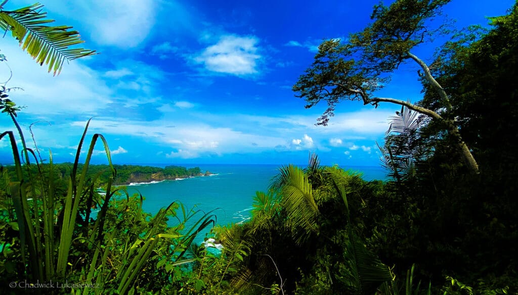 A breathtaking view of the Manuel Antonio coastline in Costa Rica, with turquoise waters and lush jungle, illustrating a sensory-friendly shooting approach for neurodivergent travelers.